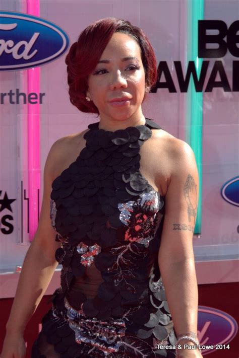 A Woman With Red Hair Wearing A Black Dress And Posing For The Camera