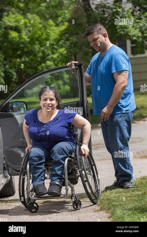 Woman With Spina Bifida And Her Husband Getting Out Of The Car Stock