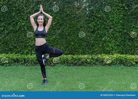 Asian Sport Woman Doing Exercise And Stretching By Yoga On The Grass