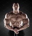 Handsome muscular bodybuilder posing over black background featuring ...