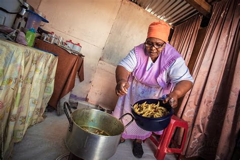 African Domestic Worker Woman Cooking By Stocksy Contributor Juno