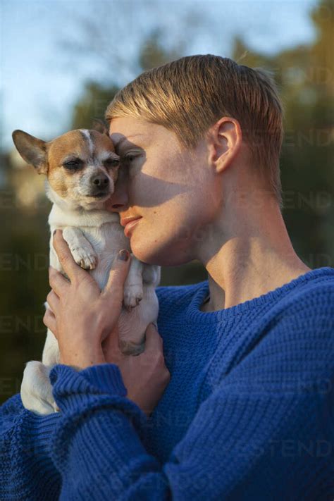 Mid Adult Woman Holding Dog Stock Photo