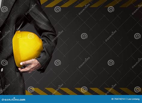 Hand Or Arm Of Engineer Hold Yellow Plastic Helmet For Worker Stock