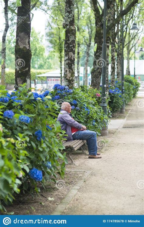 An Elderly Man Rests Sitting On A Wooden Bench Editorial Stock Photo