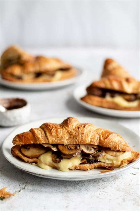 A Warm Croissant Sandwich Oozing With Melted Brie Garlic Mushrooms And