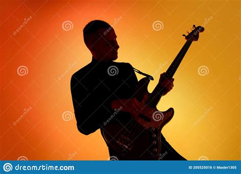 Silhouette Of Young Caucasian Male Guitarist Isolated On Orange