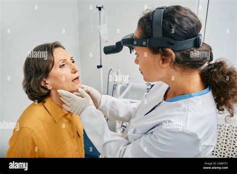 Ent Doctor Doing Throat Exam Of A Senior Woman Mature Patient Opened
