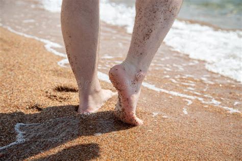 Closeup Of Bare Feet On The Beach Walking On The Sand At The Water`s Edge Vacation And Travel