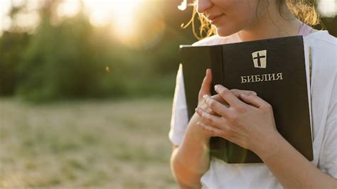 premium photo christian woman holds bible in her hands reading the holy bible in a field