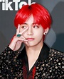 a man with red hair and piercings on his fingers is posing for the camera