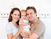 Happy mother and father holding cute baby at home — Stock Photo ...