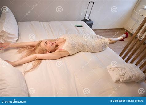 Happy Woman Stretching Lying On Soft Comfortable Hotel Bed Stock Photo