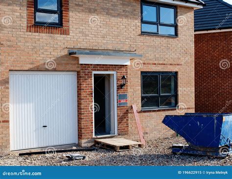 Ordinary New House for Sale and Skip on Construction Site in Front of