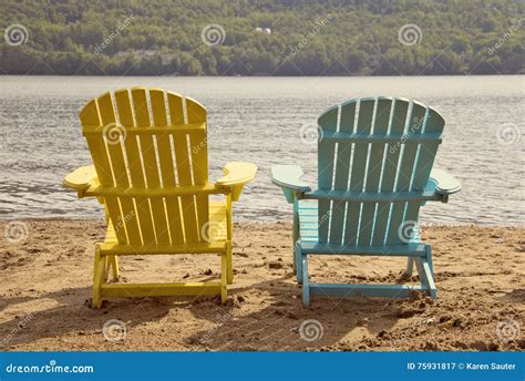 Two Adirondack Chairs On The Sandy Beach By The Lake Stock Image