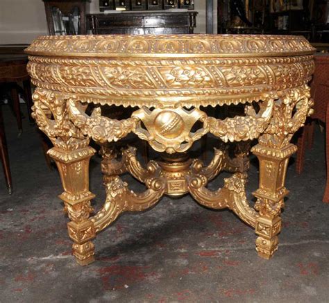 Of circular form, constructed in carved giltwood, with a scagliola the wyeth accent table has an oatmeal fabric top with double brass finish nail head design around the top edge of the table giving this piece charm. Italian Baroque Gilt Marble Centre Table