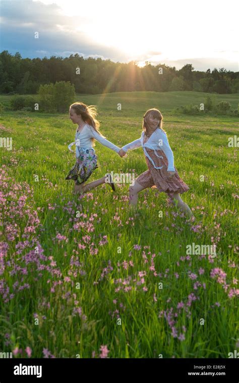 Dos Chicas Adolescentes Corriendo En Un Campo De Flores Al Atardecer