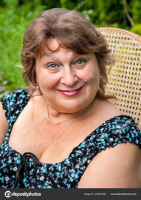Mature Plump Woman In Park Smiling And Looking At The Camera Stock