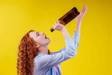 Curly Redhead Ginger Woman Drinking Beer And Feeling Bad Mood In Csudio Yellow Background Stock