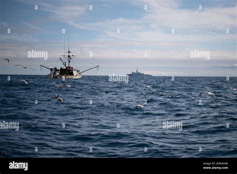 A New England Commercial Fishing Vessel Is Seen In The Foreground As