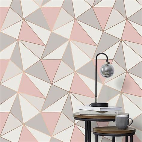 A Pink And Grey Geometric Wallpaper With A Lamp On The Table Next To It