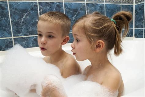 Mother And Daughter Relaxing In Bubble Filled Bath Stock Photo By