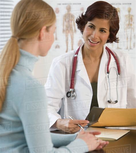 Female Doctor Talking To Woman In Office Stock Photo Dissolve