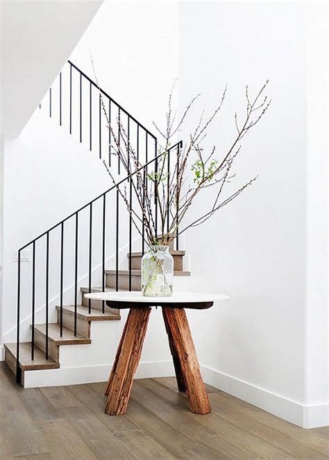 Entryway With A Large Plant And And Eclectic Table As The Focal Point
