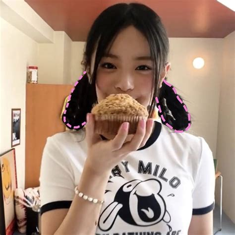 A Woman Holding A Muffin Up To Her Face