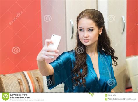 retrato de uma mulher sensual bonita no roupa interior com o telefone em sua mão foto de stock