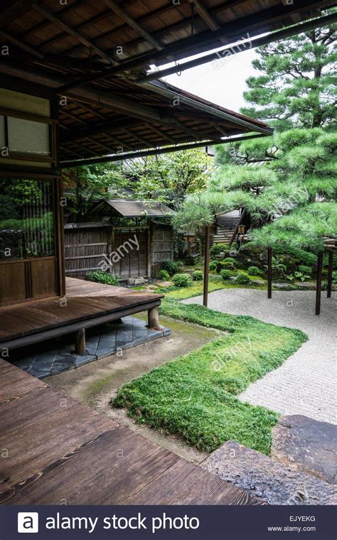 View Of A Traditional Japanese Garden With Wooden Veranda And Raked