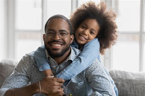 Portrait Of Happy African American Dad And Daughter Cuddling Stock