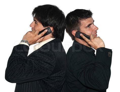 Two Young Businessmen Talking On Their Mobile Phones Stock Photo