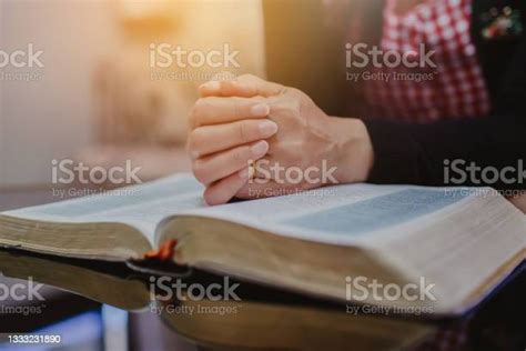 Close Up Of Womans Hands Praying On Open Bible Stock Photo Download