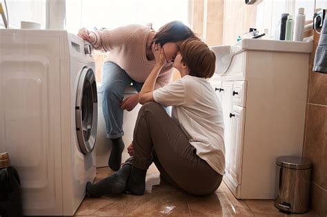 Lesbian Couple Kissing Each Other While Doing Their Laundry Work Stock