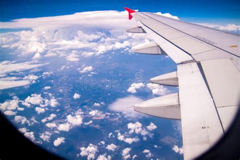 Aerial View Of Cloud Blue Sky And Plane Wing View Through The Airplane