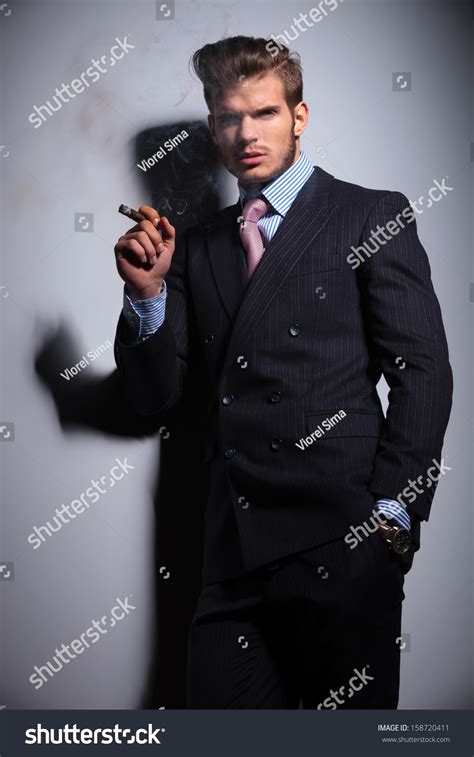Young Man In Suit And Tie With His Hand In His Pocket Is