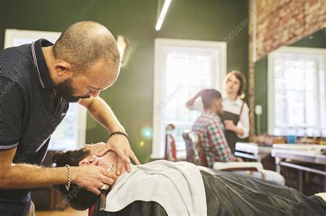 Male Barber Shaving Face Of Customer In Barbershop Stock Image F027