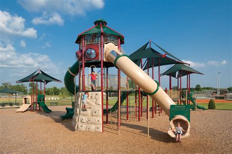 An Outdoor Play Area With Swings And Slides