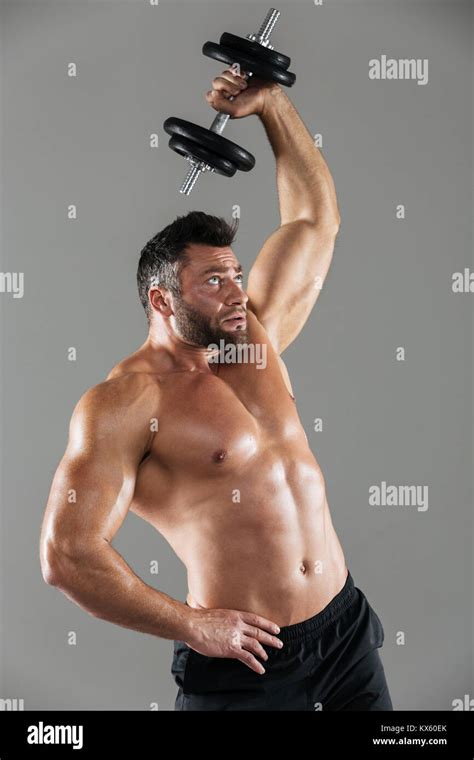 Portrait Of A Healthy Strong Shirtless Male Bodybuilder Lifting Heavy
