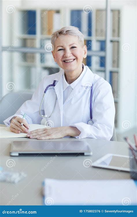 Mature Female Doctor Posing At Desk In Office Stock Photo Image Of