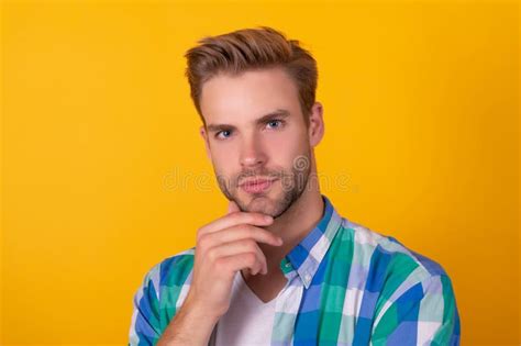 Handsome Unshaven Man Portrait Stroking Chin With Serious Look Yellow