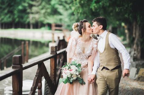 Beautiful Bride And Groom Embracing And Kissing On Their Wedding Day