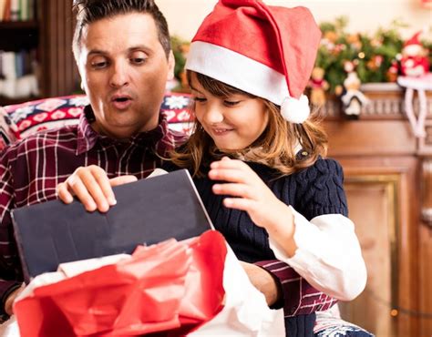 Padre E Hija Abriendo Un Regalo Foto Gratis