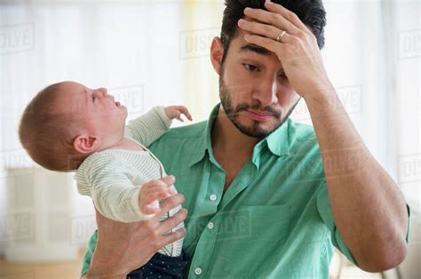 Frustrated Father Holding Crying Baby Stock Photo Dissolve
