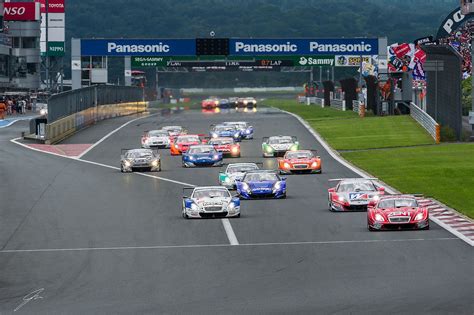 A Group Of Cars Driving Down A Race Track