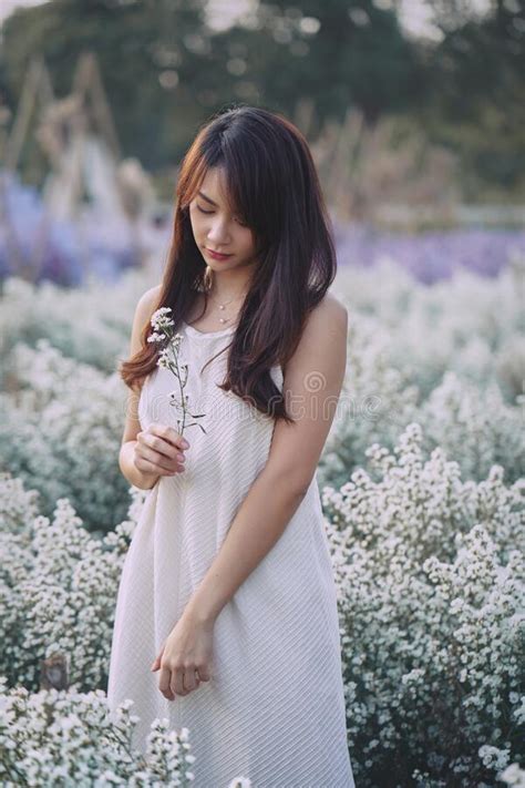 Beautiful Asian Woman Wear White Dress Walking In White Cutter Flowers