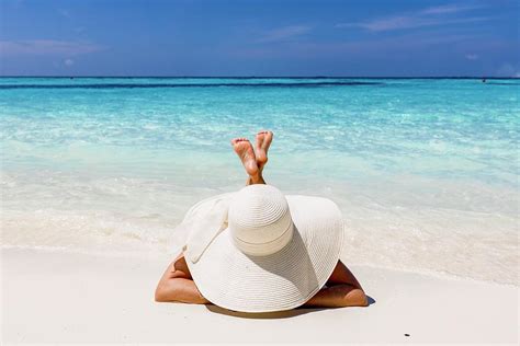 Woman With Sun Hat Sunbathing On The Beach Of Maldives Photograph By