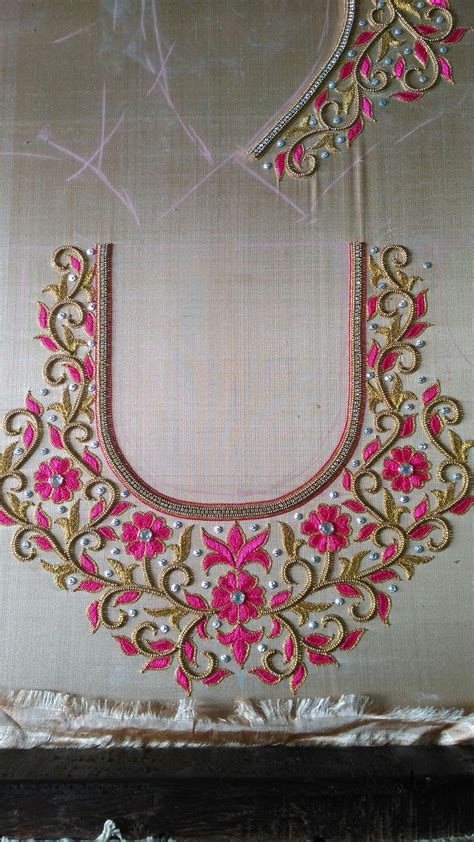 An Embroidered Piece With Pink Flowers And Gold Trimmings Sits On A