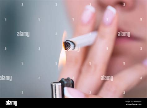 Closeup Of Young Woman Lighting Cigarette With Lighter Smoking