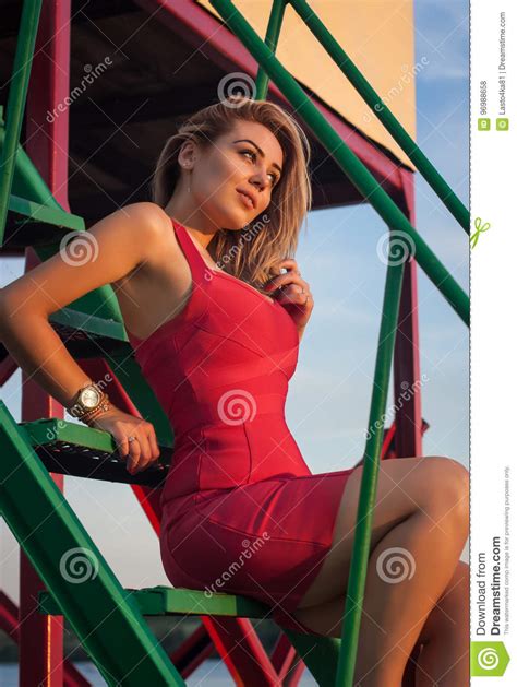 Schöne Blondine In Einem Sexy Roten Kleid Sitzt Auf Den Schritten Stockfoto Bild Von Sinnlich